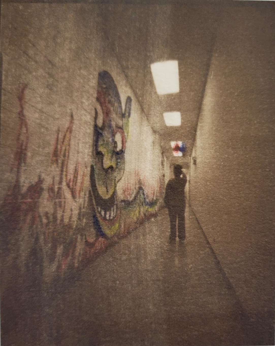 A Van Dyke Brown print of a long hallway. A figure faces away from the views down the hall, looking up at red and blue shapes that have been hand drawn onto the photo. A green goblin like creature has been spraypainted on the left side of the hall and peeks down the hallway in the opposite direction of the figure.